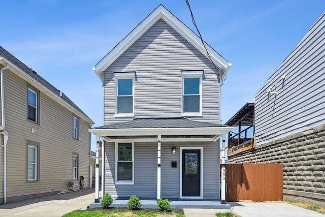 traditional-style house featuring fence and covered porch