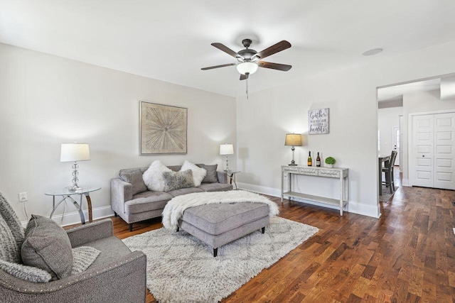 living area featuring baseboards, ceiling fan, and wood finished floors