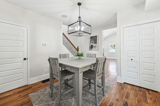 dining room featuring dark wood-style flooring, visible vents, baseboards, an inviting chandelier, and stairs