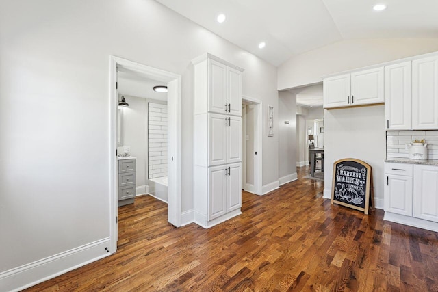 kitchen with dark wood-type flooring, recessed lighting, white cabinetry, and vaulted ceiling