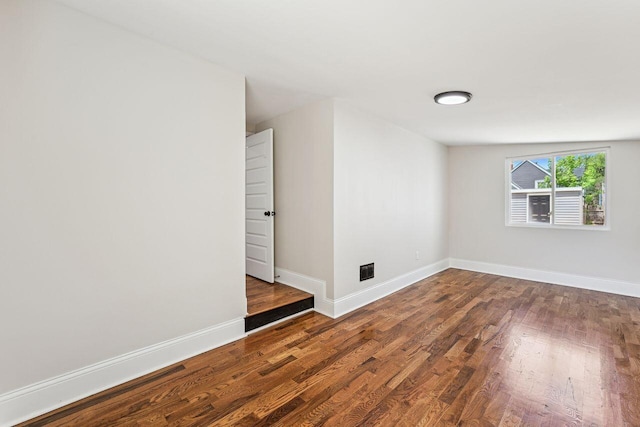 empty room featuring baseboards and wood finished floors