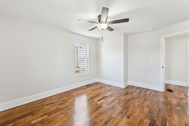spare room featuring baseboards, a ceiling fan, wood finished floors, and visible vents