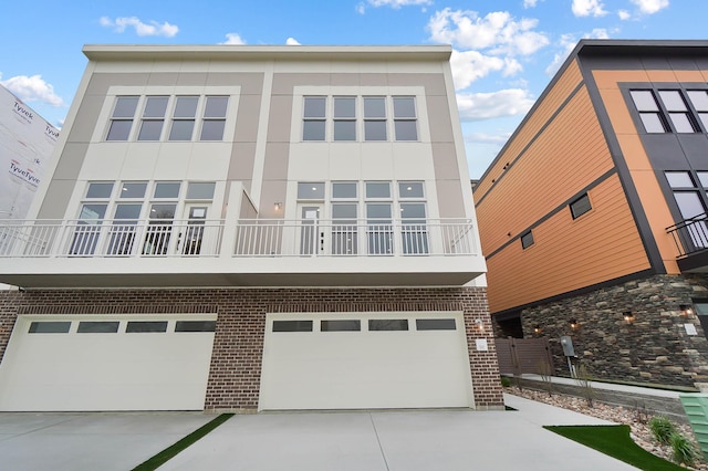 exterior space with stucco siding, a balcony, brick siding, and a garage