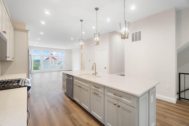 kitchen featuring a sink, light wood-type flooring, visible vents, light countertops, and appliances with stainless steel finishes