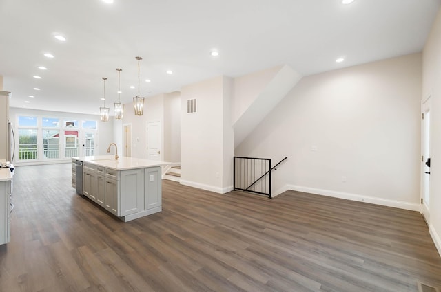 kitchen with recessed lighting, dark wood-style flooring, a center island with sink, visible vents, and baseboards