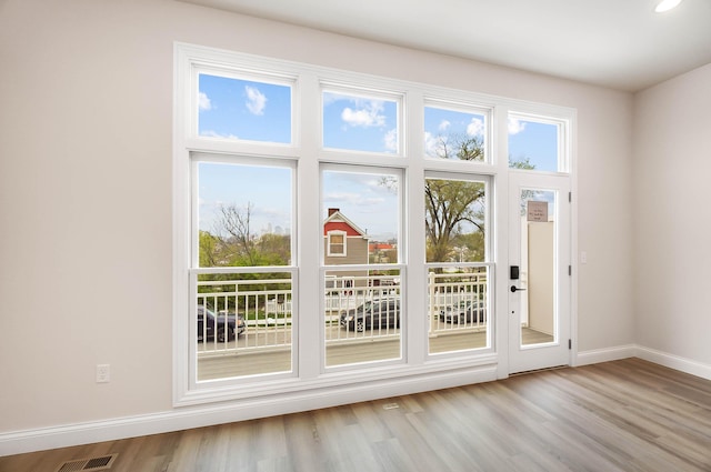doorway featuring visible vents, wood finished floors, and baseboards