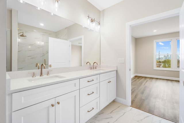 bathroom featuring double vanity, a marble finish shower, marble finish floor, and a sink
