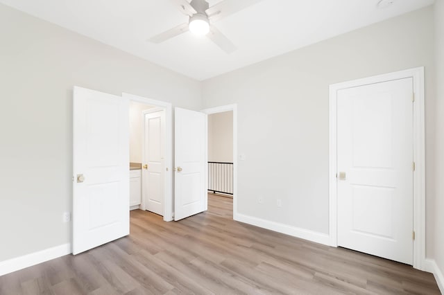 unfurnished bedroom with light wood-style floors, a ceiling fan, and baseboards