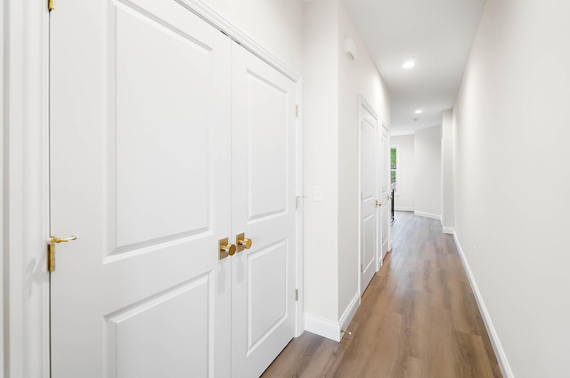 hall with baseboards, recessed lighting, and wood finished floors