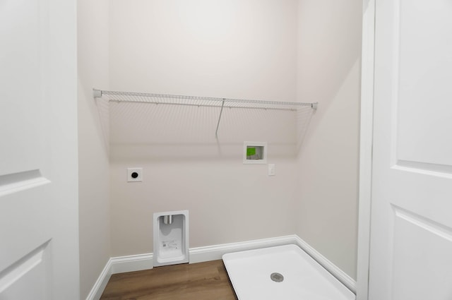 clothes washing area with hookup for an electric dryer, washer hookup, laundry area, baseboards, and wood finished floors