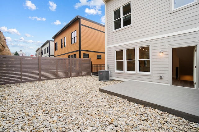 rear view of property featuring central AC and a fenced backyard