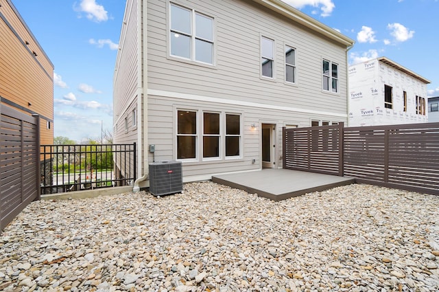 rear view of house with a fenced backyard and central air condition unit