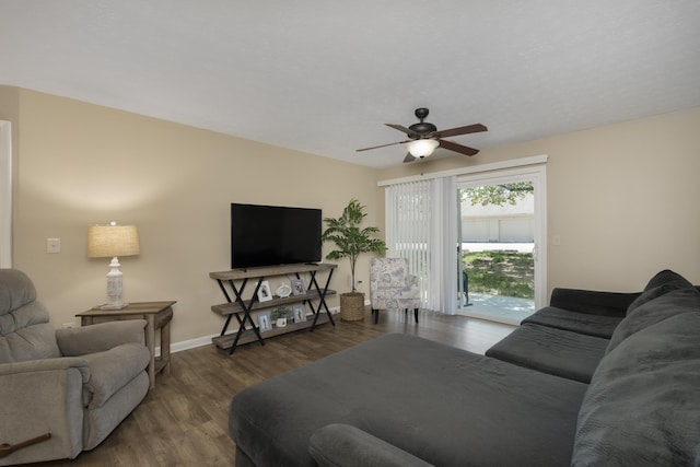 living area with a ceiling fan, wood finished floors, and baseboards