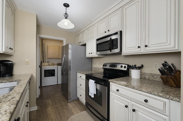 kitchen with appliances with stainless steel finishes, washer and clothes dryer, wood finished floors, and white cabinetry