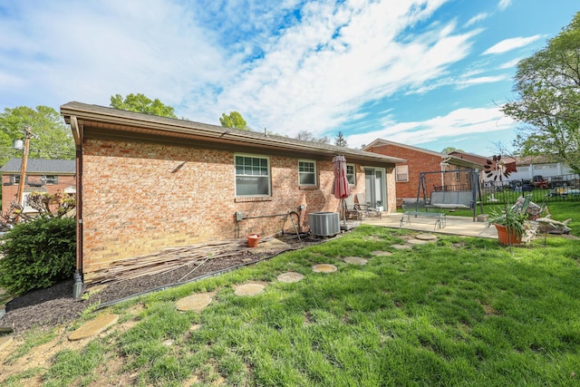 48 Bonnie Ln, Fort Thomas, KY 41075 - back of house with central AC unit, a patio area, a lawn, brick siding, and fence