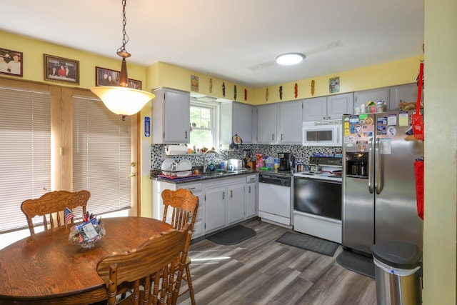 48 Bonnie Ln, Fort Thomas, KY 41075 - kitchen featuring dark countertops, decorative light fixtures, dark wood-type flooring, white appliances, and backsplash