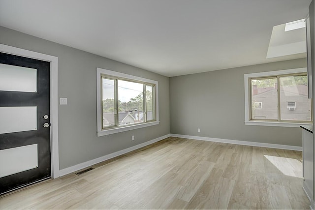 entryway featuring baseboards, light wood-type flooring, and visible vents