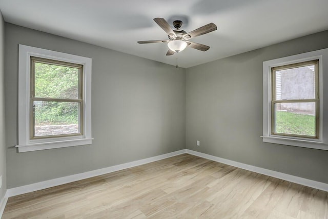 empty room featuring baseboards and light wood finished floors