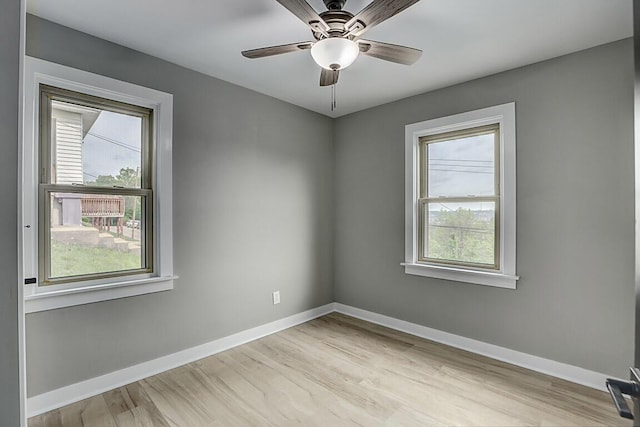 unfurnished room with baseboards, a ceiling fan, and light wood-type flooring