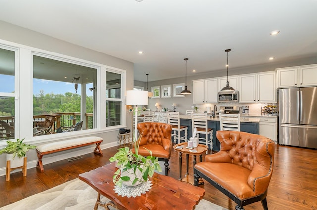 living area featuring recessed lighting, dark wood finished floors, and baseboards