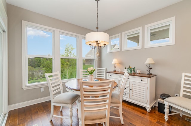 dining space featuring dark wood-style flooring, a chandelier, plenty of natural light, and baseboards