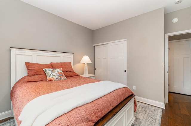 bedroom featuring wood finished floors, a closet, and baseboards