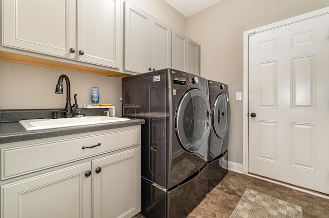 laundry area featuring washer and dryer, cabinet space, and a sink