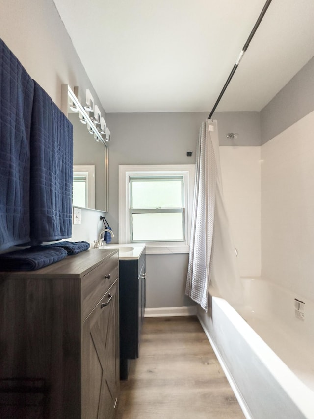 510 Fox St, Elsmere, KY 41018 - full bath featuring wood finished floors, vanity, shower / bath combo with shower curtain, and healthy amount of natural light