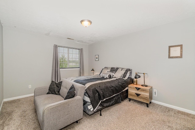 bedroom featuring baseboards, visible vents, and light carpet