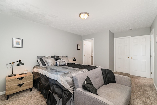 bedroom featuring a textured ceiling, light carpet, and baseboards