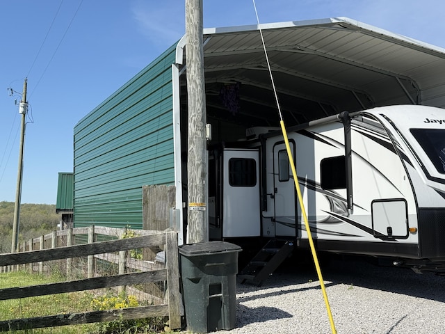 view of vehicle parking with a carport and fence