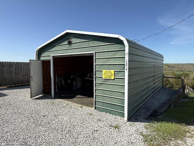 view of outbuilding with fence and an outdoor structure
