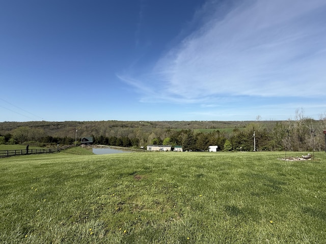 view of yard with a rural view and fence