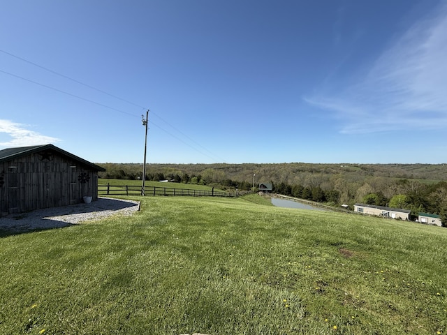 view of yard featuring an outdoor structure and fence