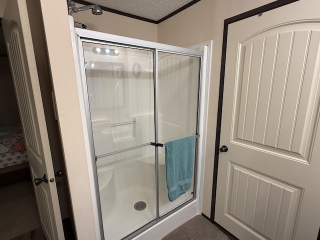 full bathroom featuring a shower stall and a textured ceiling