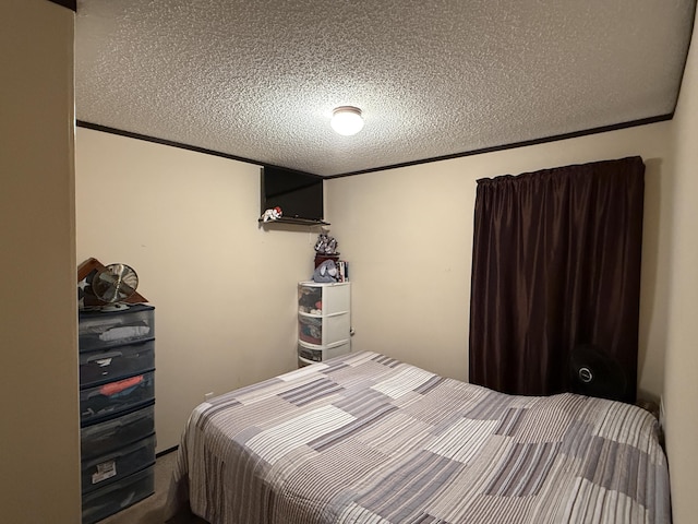 bedroom with a textured ceiling and crown molding