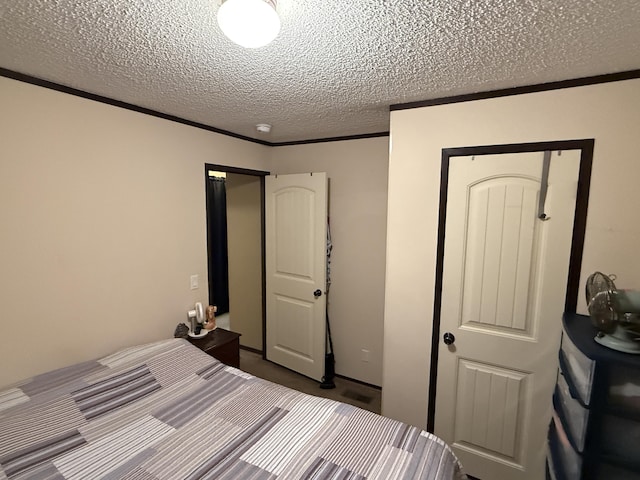 bedroom featuring crown molding, a textured ceiling, and carpet