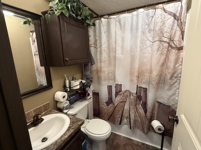bathroom featuring toilet, a textured ceiling, and vanity