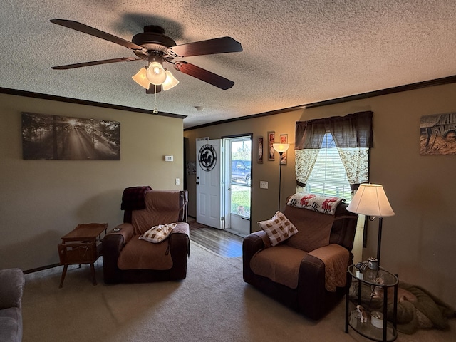 living room featuring ceiling fan, a textured ceiling, and crown molding