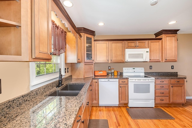 kitchen with white appliances, glass insert cabinets, a sink, and light wood-type flooring