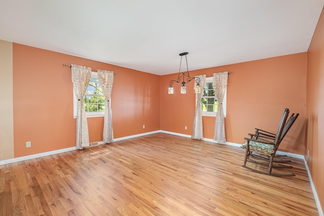 unfurnished room with baseboards, light wood-style flooring, and visible vents