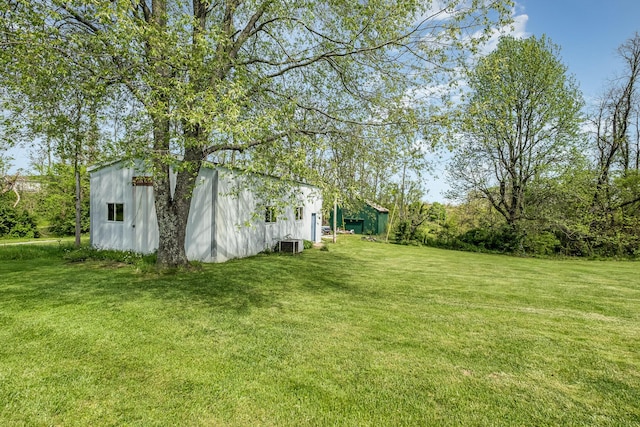 view of yard with central air condition unit and an outdoor structure