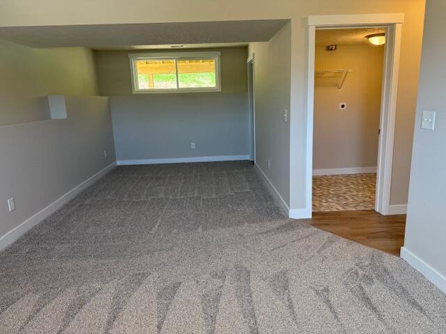 unfurnished room with carpet floors and baseboards