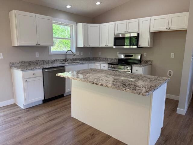 kitchen featuring white cabinetry, baseboards, appliances with stainless steel finishes, and a sink