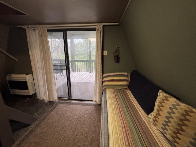 bedroom with heating unit and access to exterior