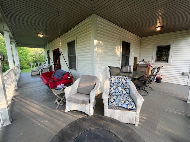 wooden terrace with a porch and outdoor dining space