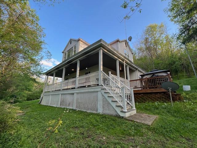 rear view of property featuring a yard and stairway