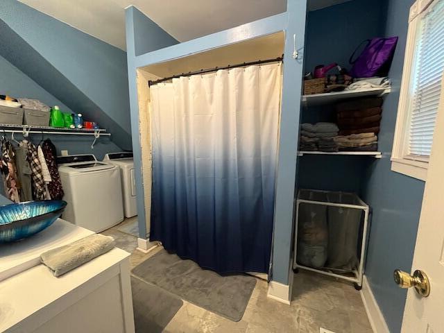 clothes washing area with a healthy amount of sunlight, baseboards, laundry area, and washer and clothes dryer
