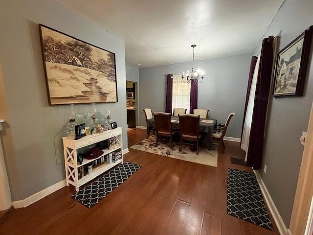 dining room with baseboards, wood finished floors, and a notable chandelier