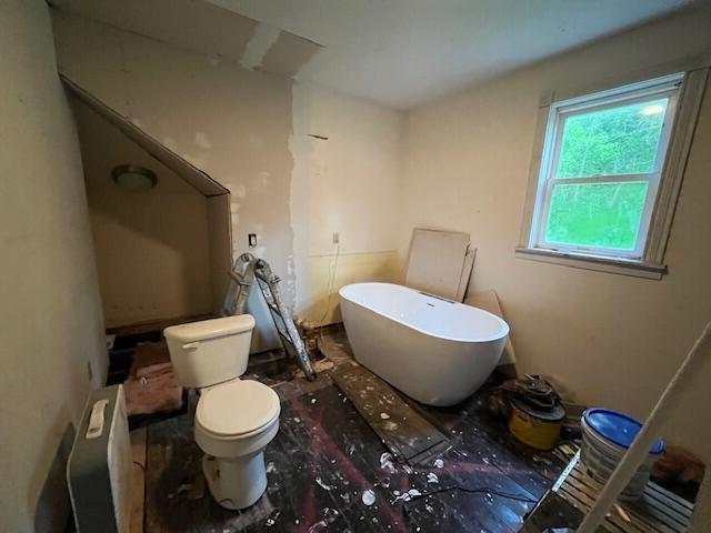 full bathroom with a freestanding bath and toilet